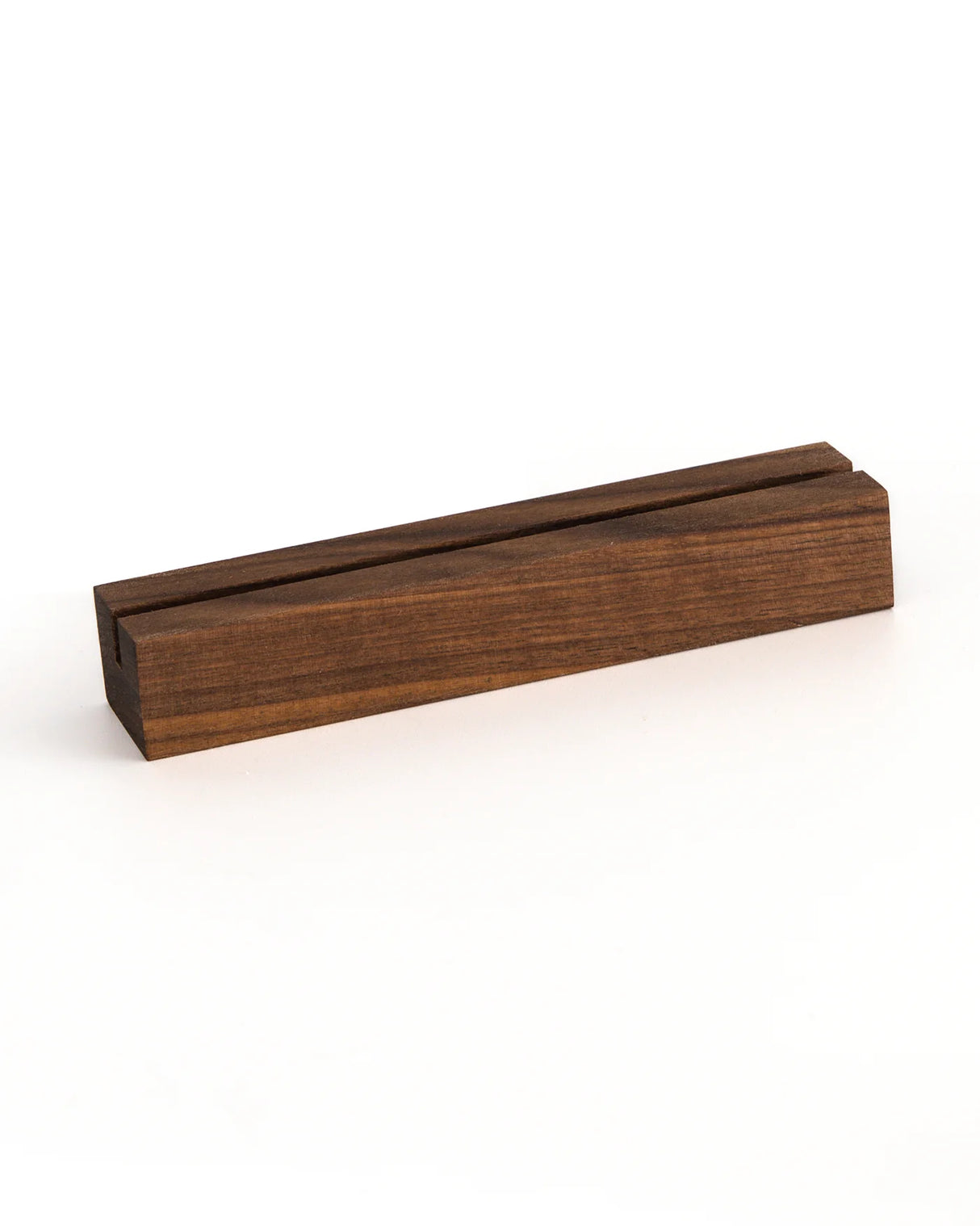 A dark brown wooden block with a recessed groove on top, shown at an angle on a clean white background.
