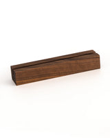 A dark brown wooden block with a recessed groove on top, shown at an angle on a clean white background.